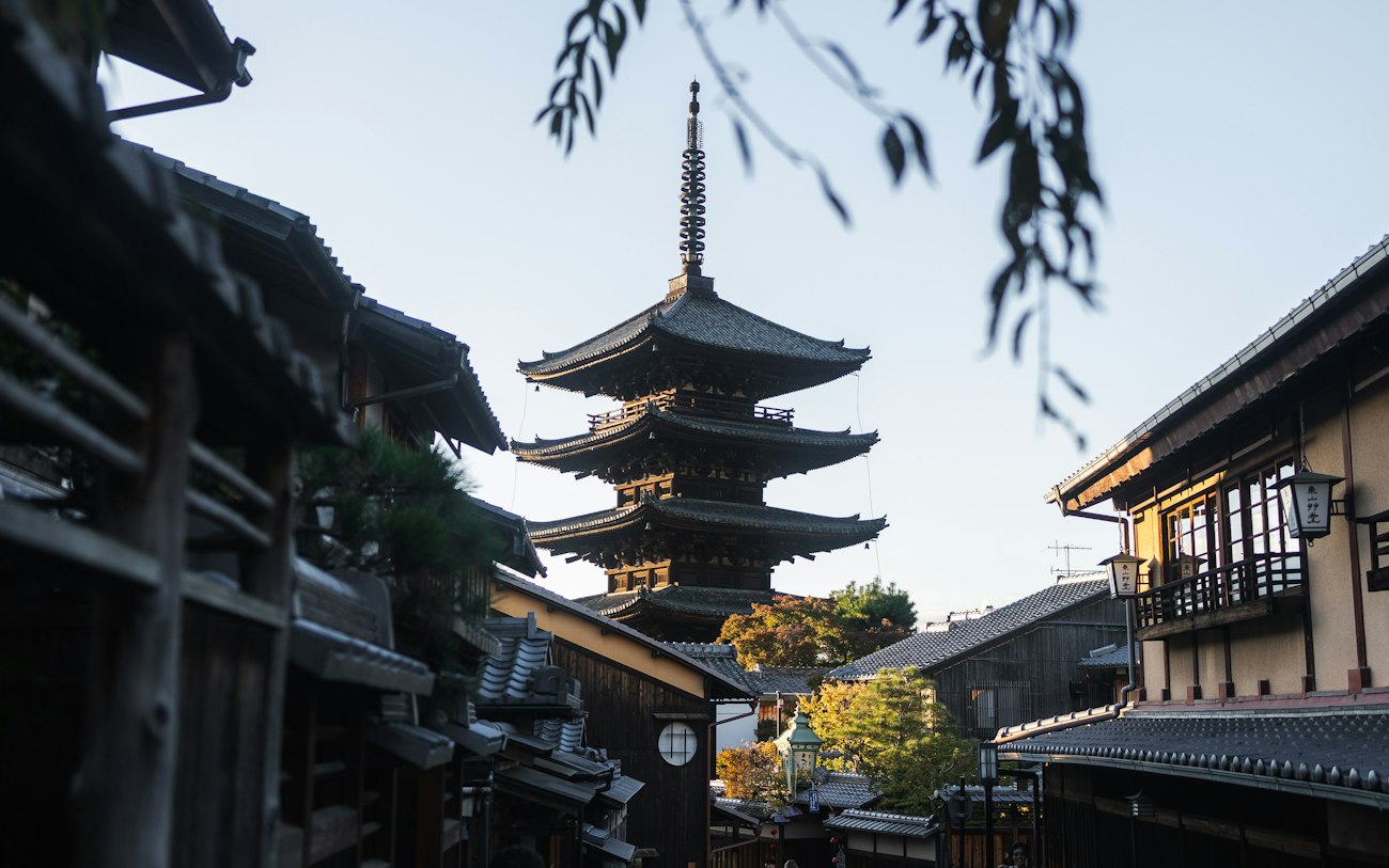 Eine schmale Straße mit einer hohen Pagode im Hintergrund