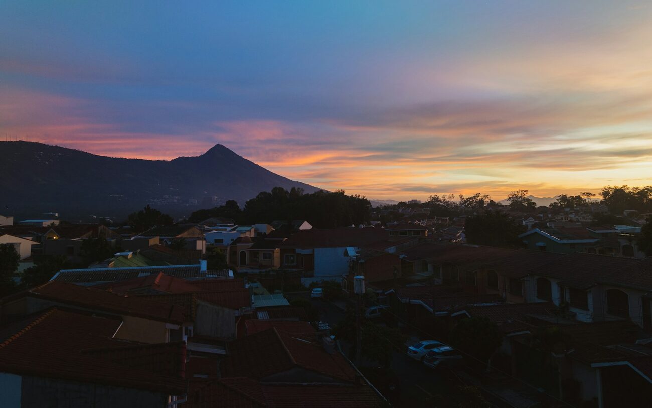 Sunset over San Salvador with a volcano on the horizon.