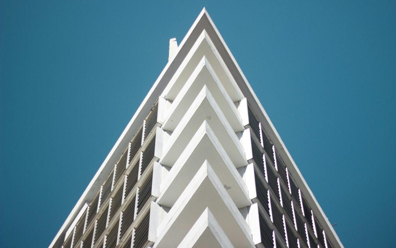 A modern white apartment tower in Asunción against a blue sky.