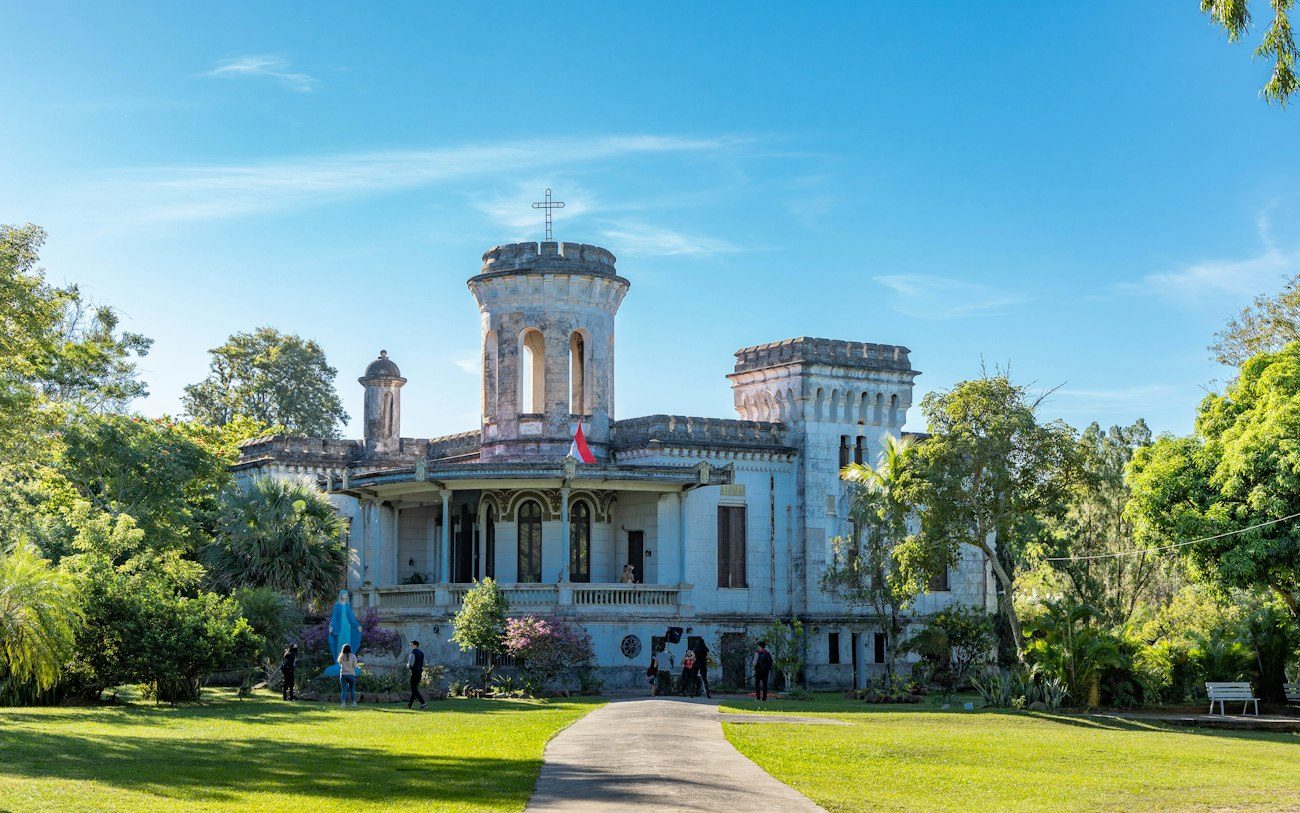 A grand villa with a lawn and tower in Areguá, Paraguay.