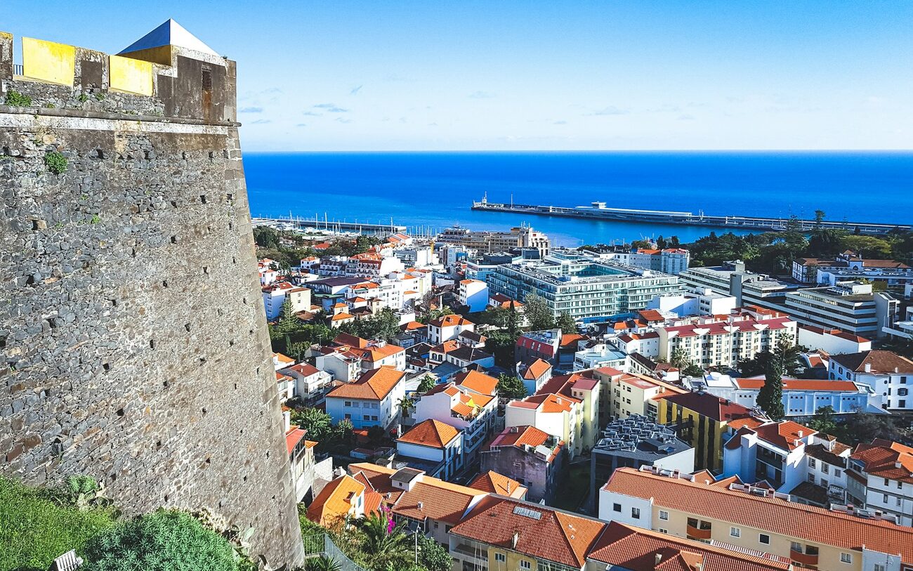 Funchal's old town below the São Tiago fort, with the harbour and Atlantic beyond.