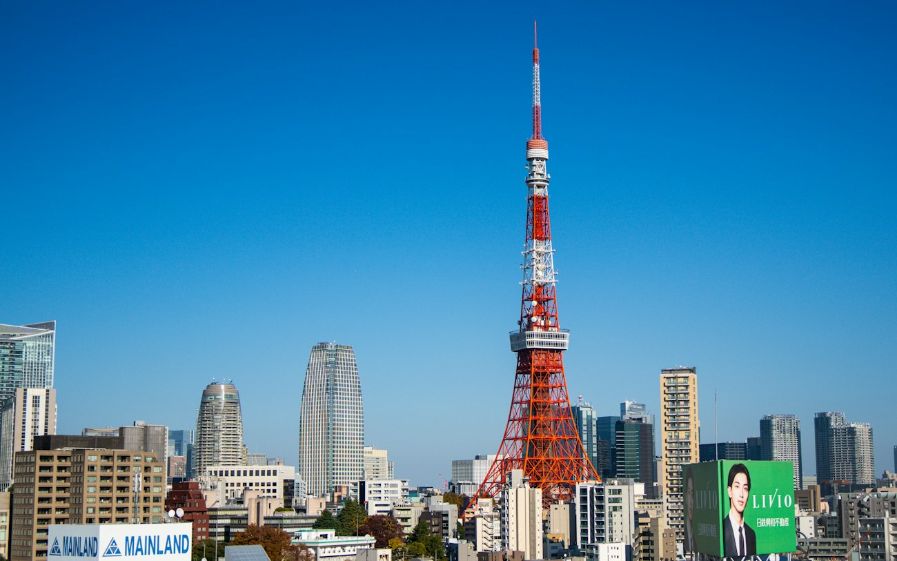 Der Tokyo Tower ragt unter klarem Himmel inmitten der Stadtlandschaft empor